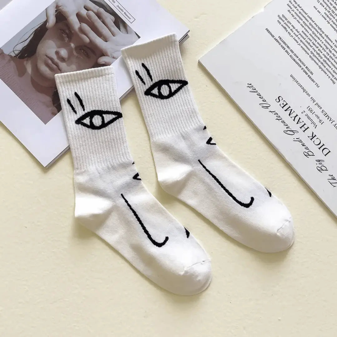 White abstract line art crew socks with expressive artisan face designs, unique wearable art footwear
