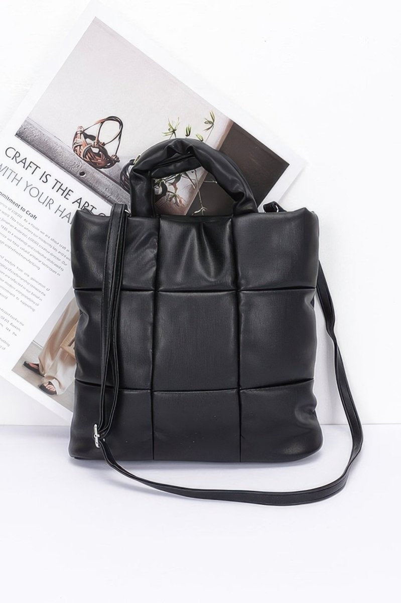 Black quilted faux leather tote bag with padded panels and detachable shoulder strap