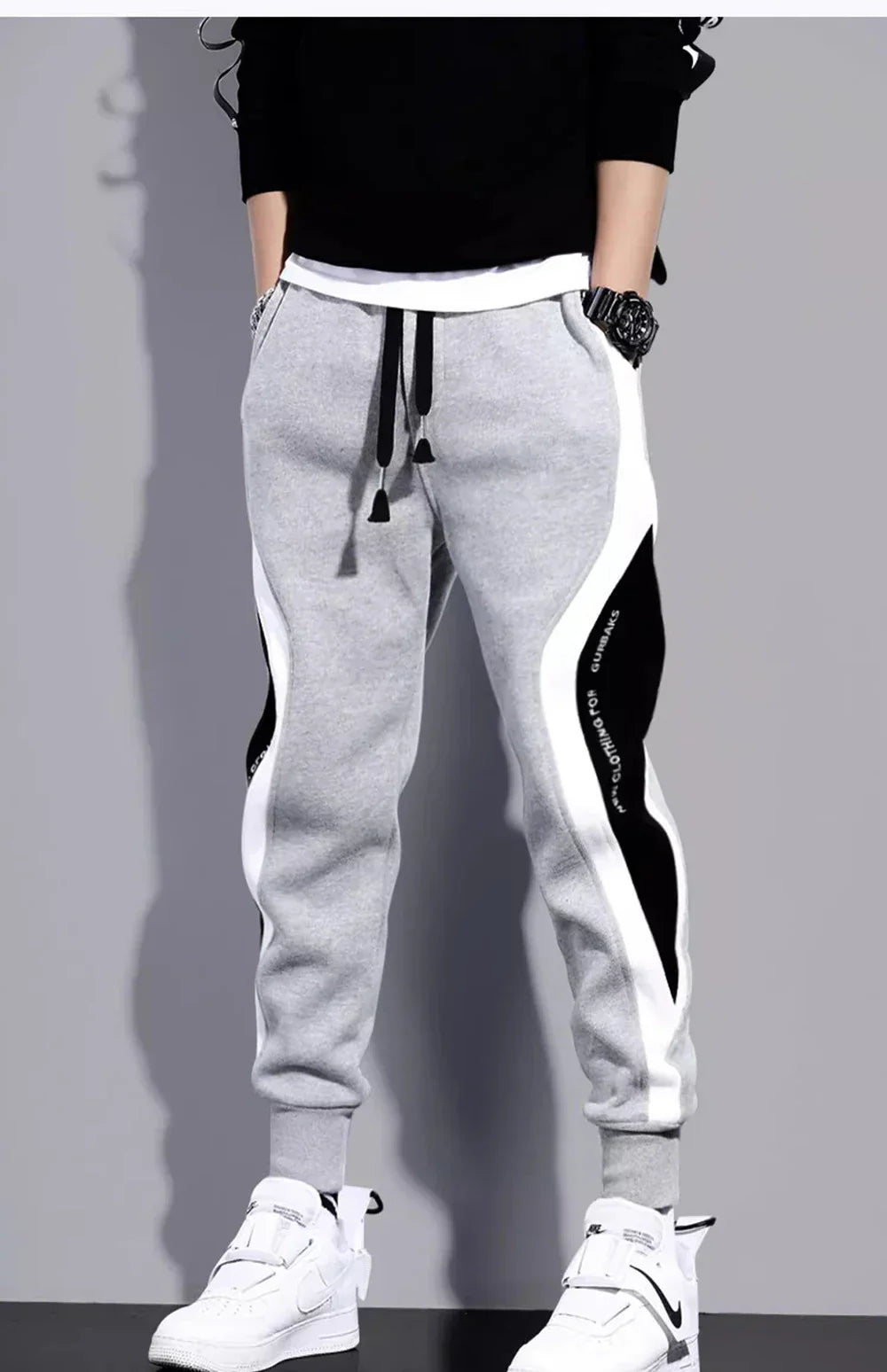 Men's loose fit gray sports pants with bold patchwork side panels, relaxed athletic cut for spring