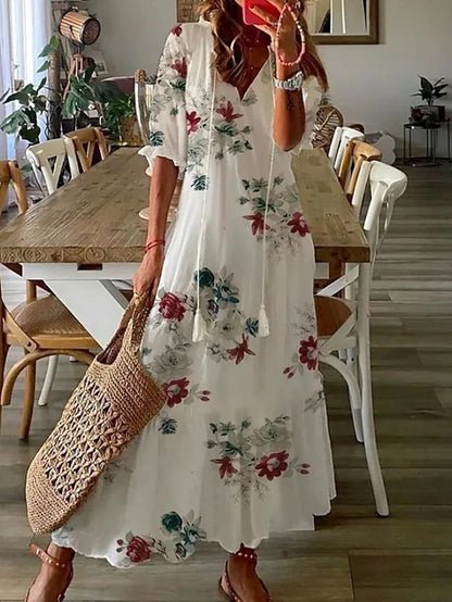 Boho floral maxi dress with V-neckline, tassel ties, flowy sleeves, and relaxed silhouette