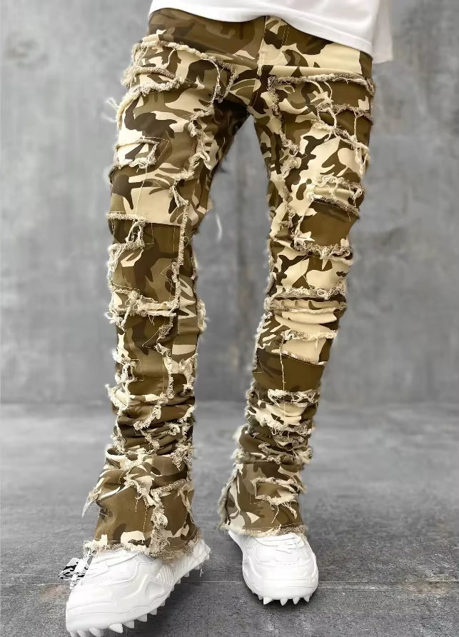 Blue distressed layered denim tapered jeans with heavy fraying and reinforced seams streetwear style