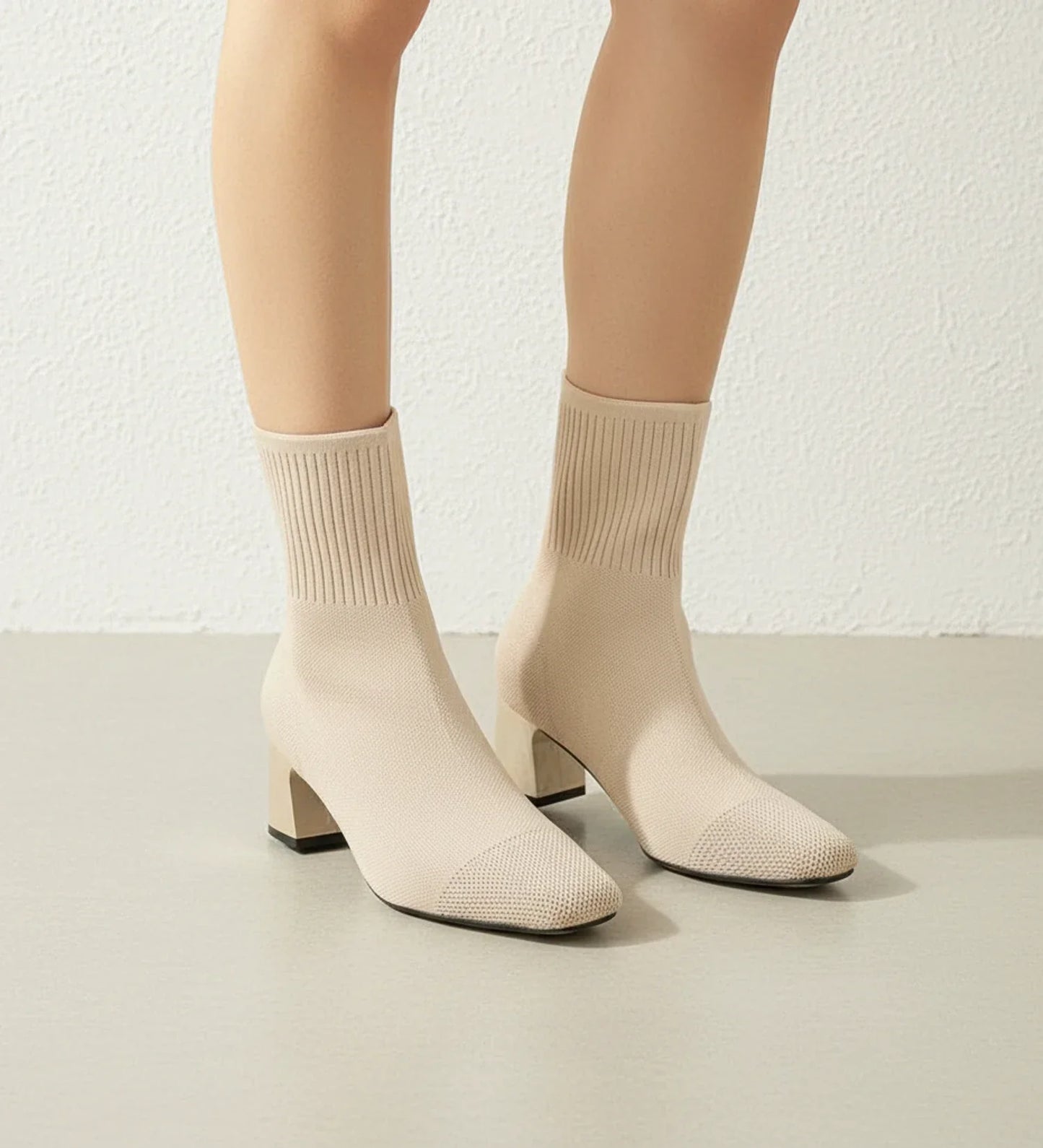 Black sock-knit ankle boots with block heel, stretchy form-fitting upper, sleek contemporary style