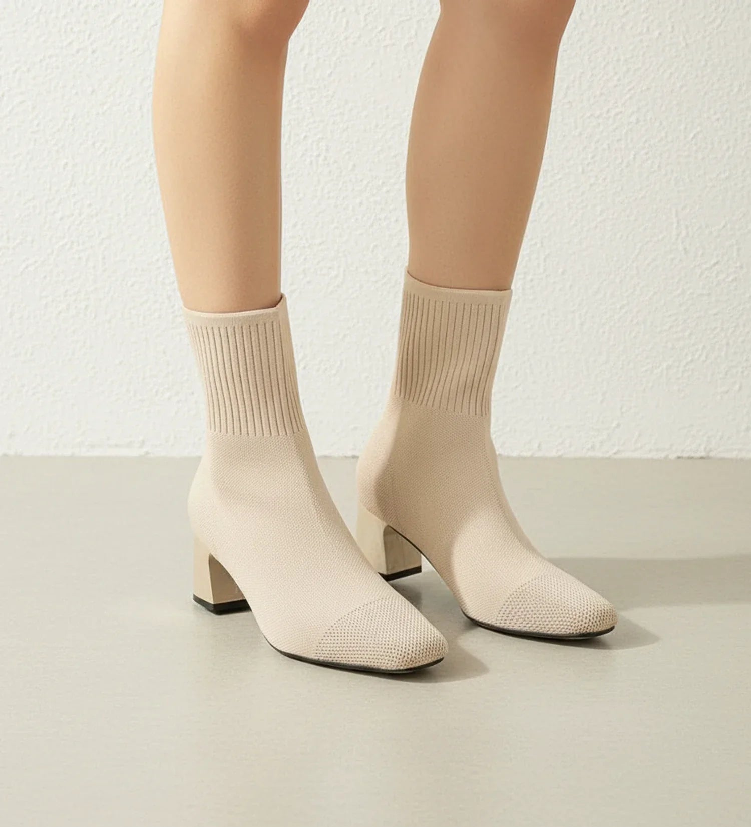 Black sock-knit ankle boots with block heel, stretchy form-fitting upper, sleek contemporary style