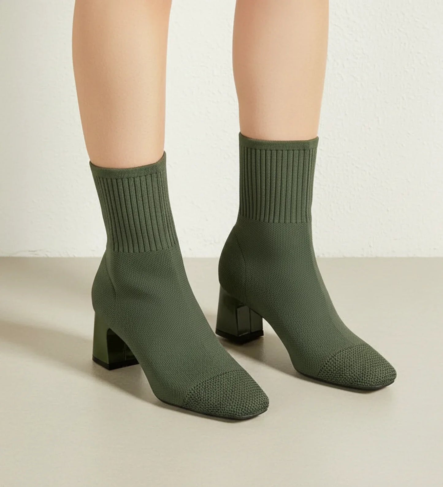 Black sock-knit ankle boots with block heel, stretchy form-fitting upper, sleek contemporary style