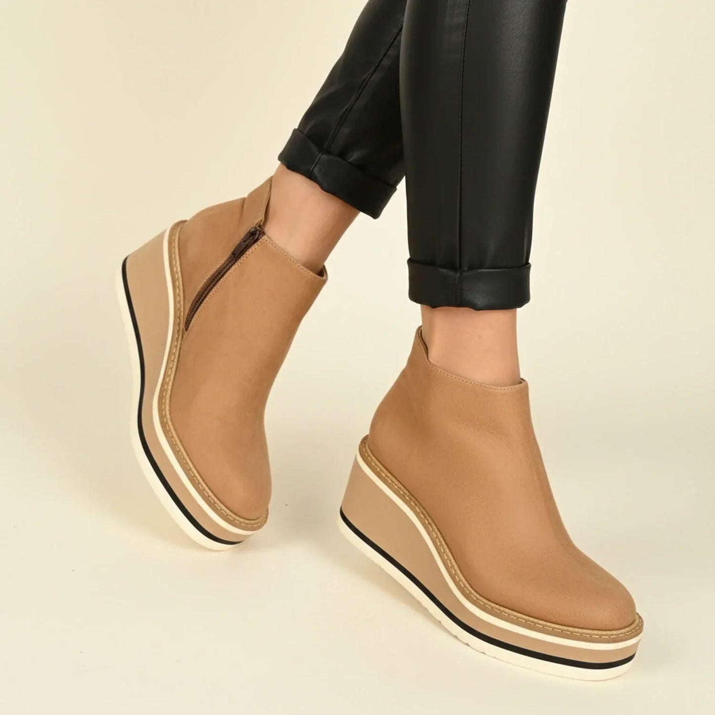 Women's black leather wedge ankle boots with sleek silhouette and height-elevating sole for everyday style