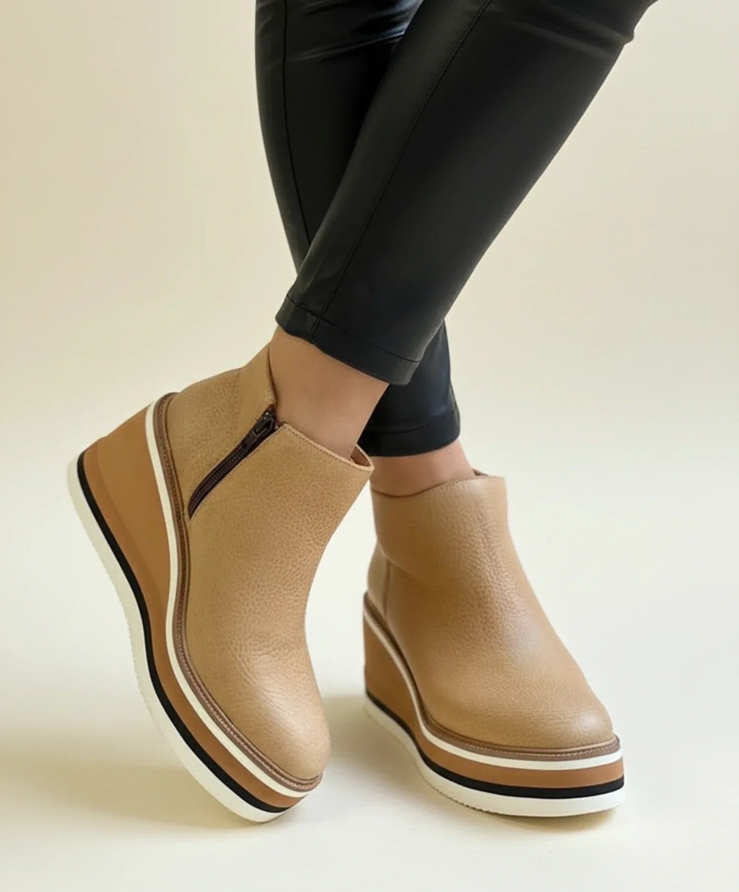 Women's black leather wedge ankle boots with sleek silhouette and height-elevating premium sole