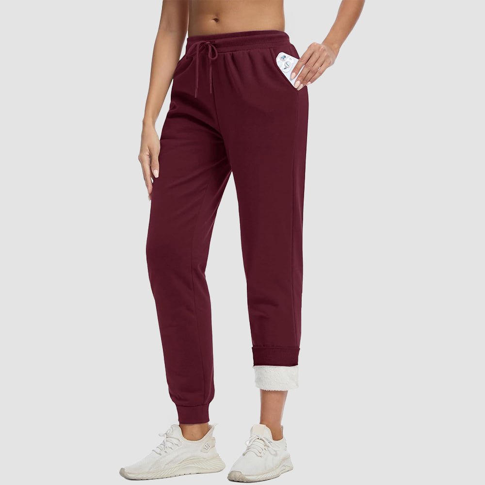 Women's sherpa lined fleece joggers in cozy winter style with deep side pockets for warmth